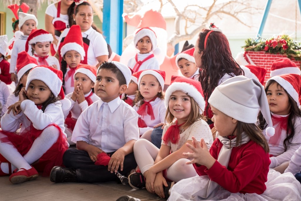 Ellia sitting with her class at a Christmas presentation