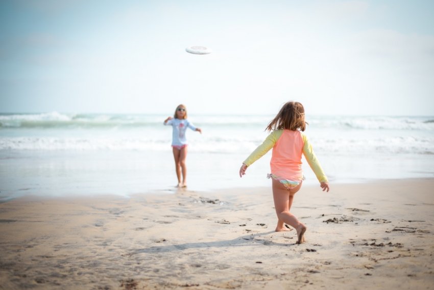 Girls playing frisbee on the beach